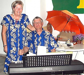 Sonja och Alex i vårblommig dress (i bakgrunden prisbordet).